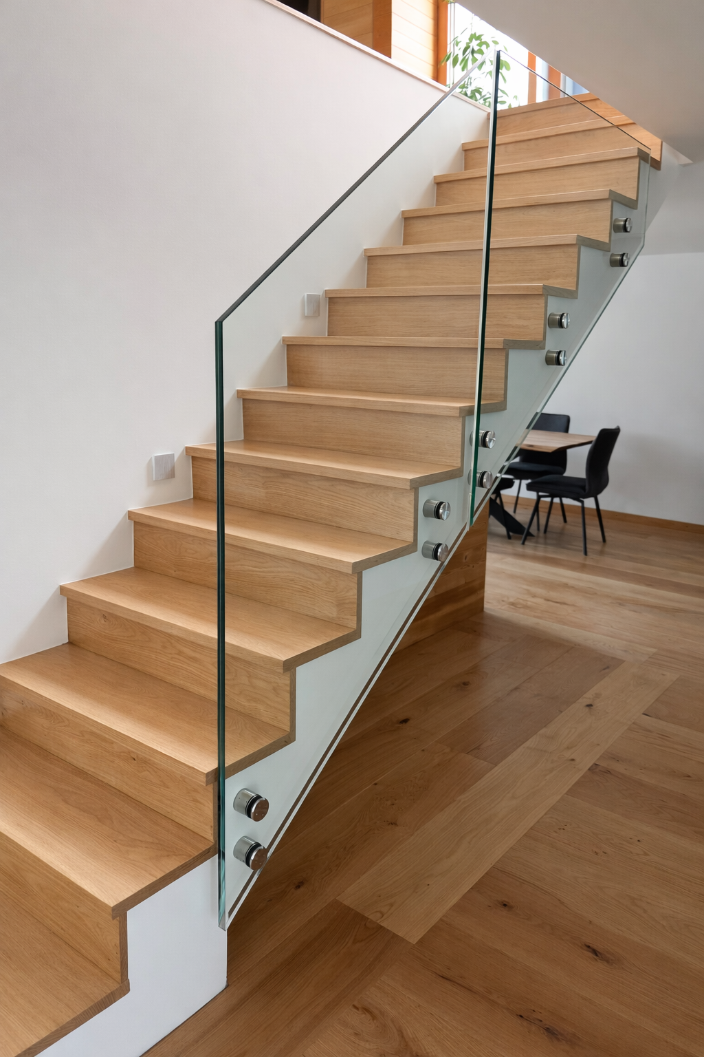 Escalier en bois avec garde-corps en verre trempé fixé par points inox, réalisation sur mesure.